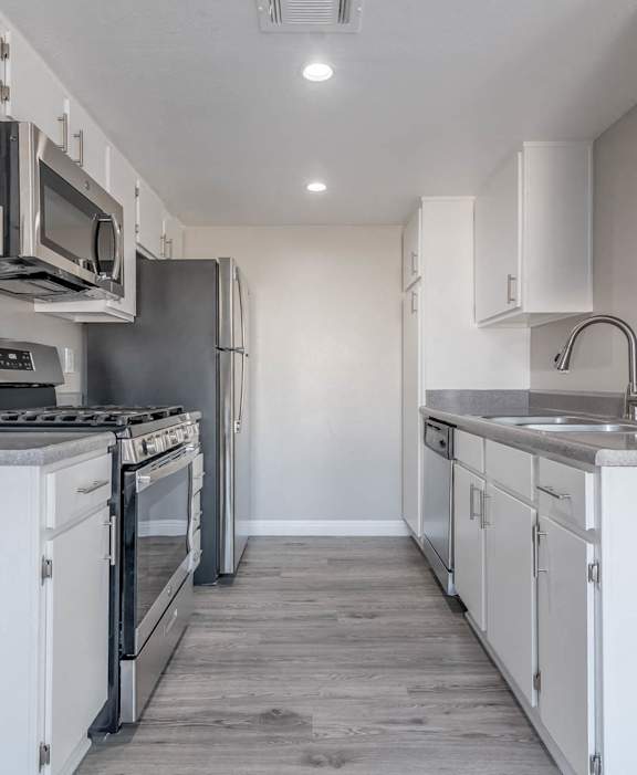 A kitchen with white cabinets and stainless steel appliances.