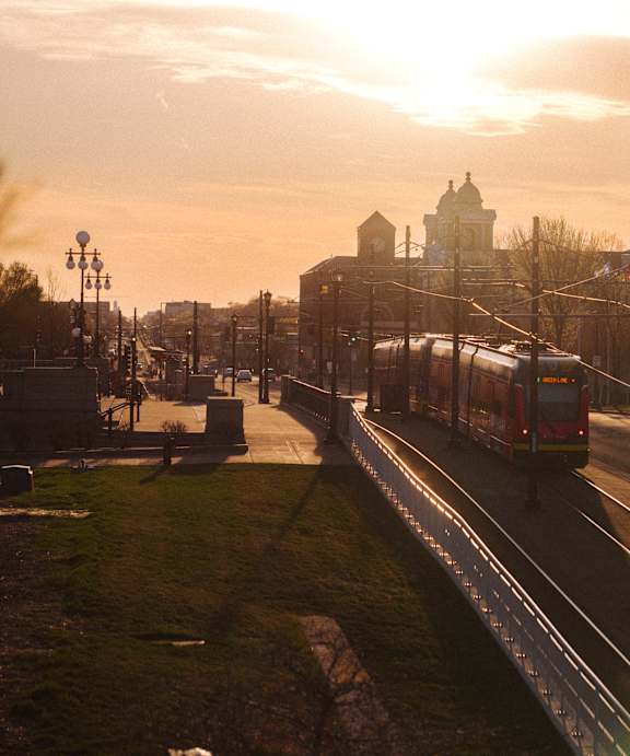 A train is traveling down the tracks in a city.