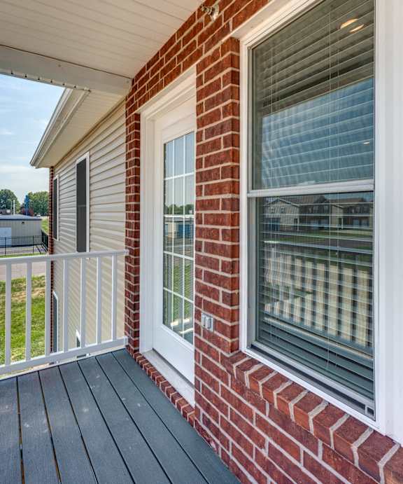 A house with a red brick wall and a white window.