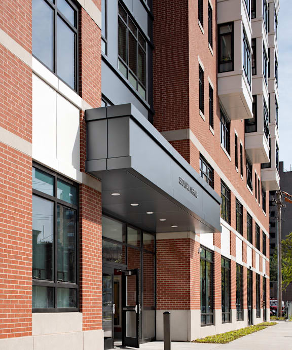 A modern building with a red brick facade and a white entrance.
