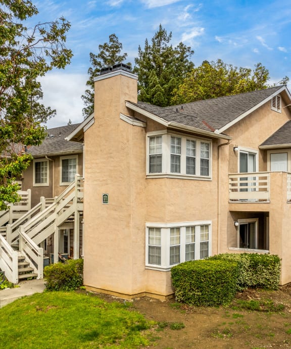 the front of a house with a yard and stairs