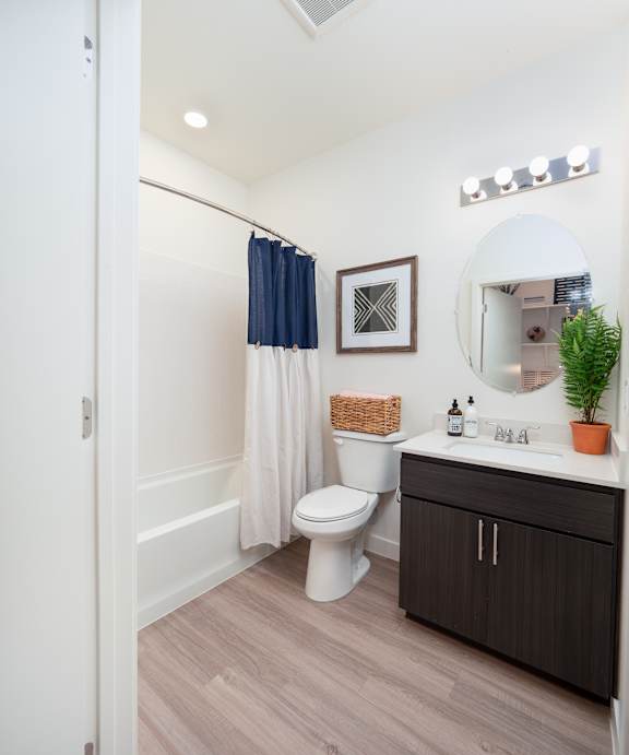 A bathroom with a toilet, sink, and a mirror.