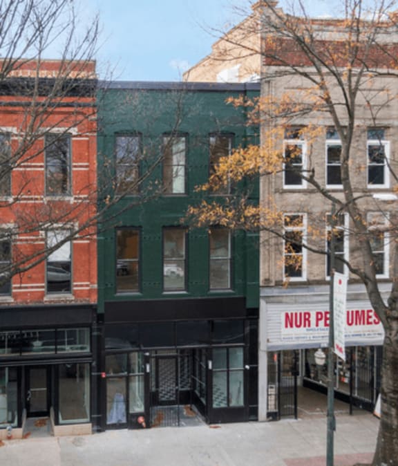 a green building on the corner of a city street
