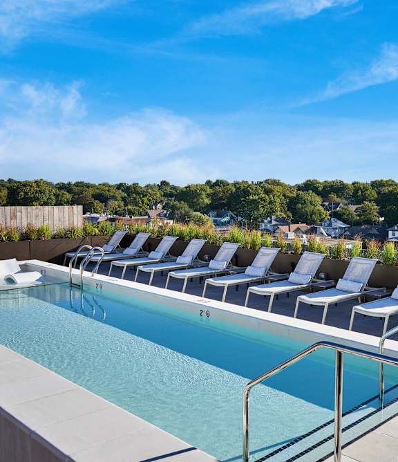 A pool with chairs and a metal railing.