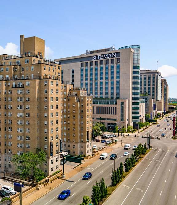 A city street with cars and buildings including one with the word "STEAM" on it.