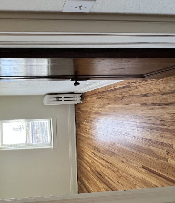 a bedroom with a sliding door and a wood floor