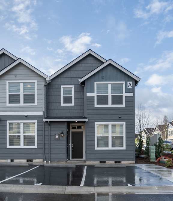 A row of modern houses with grey exteriors and white windows.