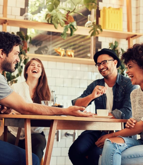 a group of people sitting around a table laughing