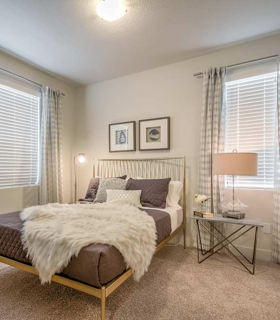 A bedroom with a bed, nightstand, and window.
