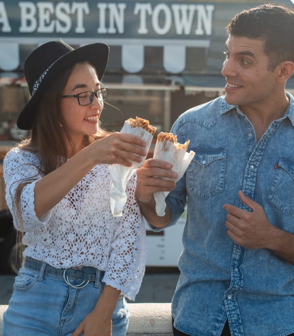 a man and woman standing in front of a food truck