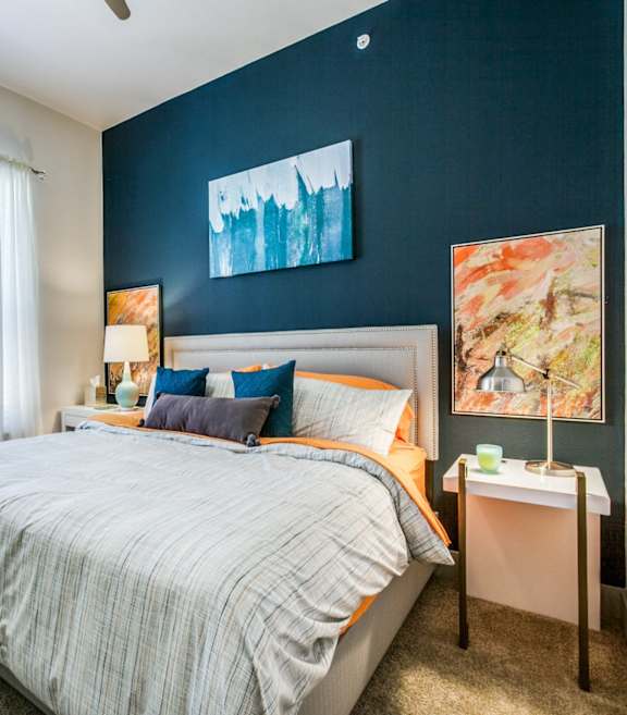 A bedroom with a bed, nightstand, and two lamps.