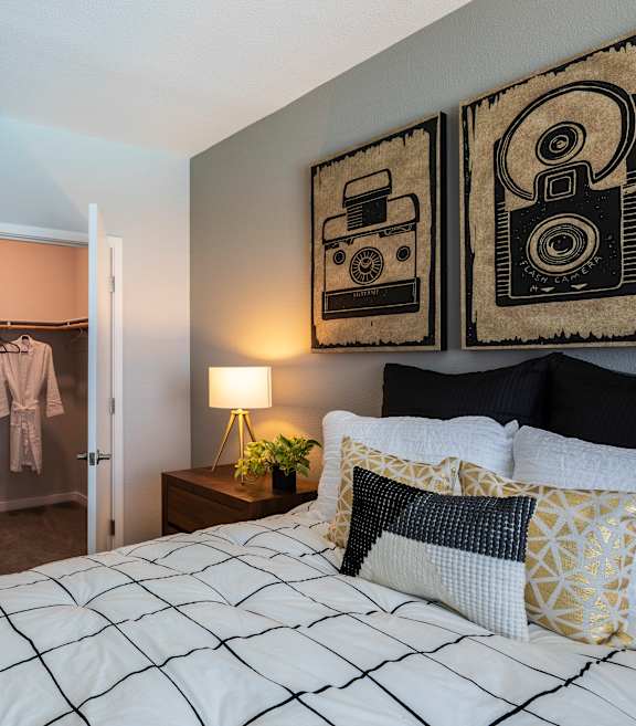 a bedroom with a bed and a nightstand with a lamp