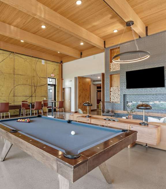 a living room with a pool table and a fireplace