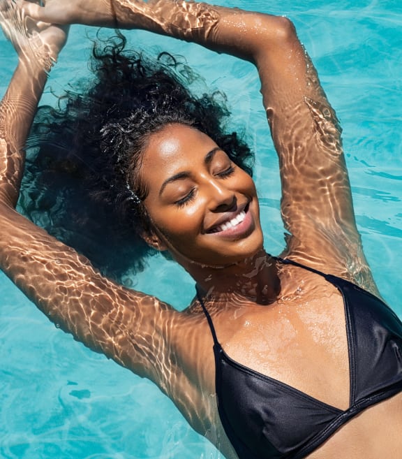 a woman swimming in a pool with her hands in the water