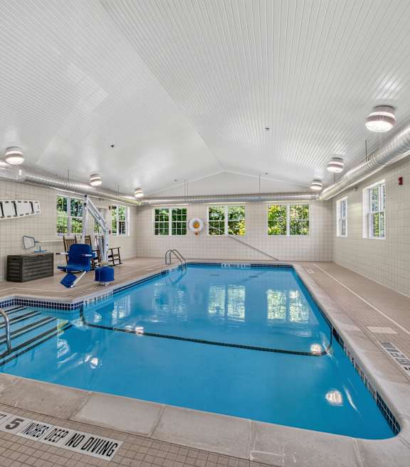 A bedroom with a bed, nightstand, and a ceiling fan.at Glenmont Abbey Village, 55+ Apartments, New Jersey, 12077