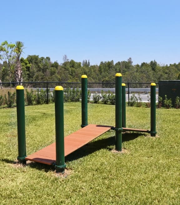 a swing set in a park with a fence at The Atlantic Doral, Doral, FL, 33178