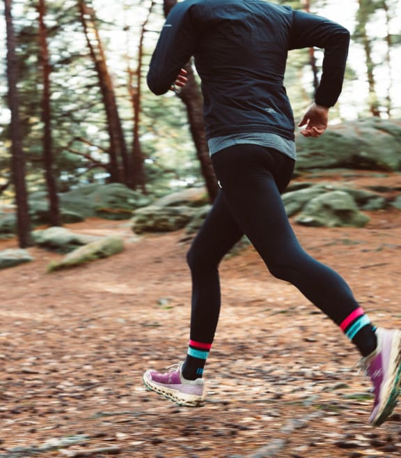 a man running on a trail in the woods