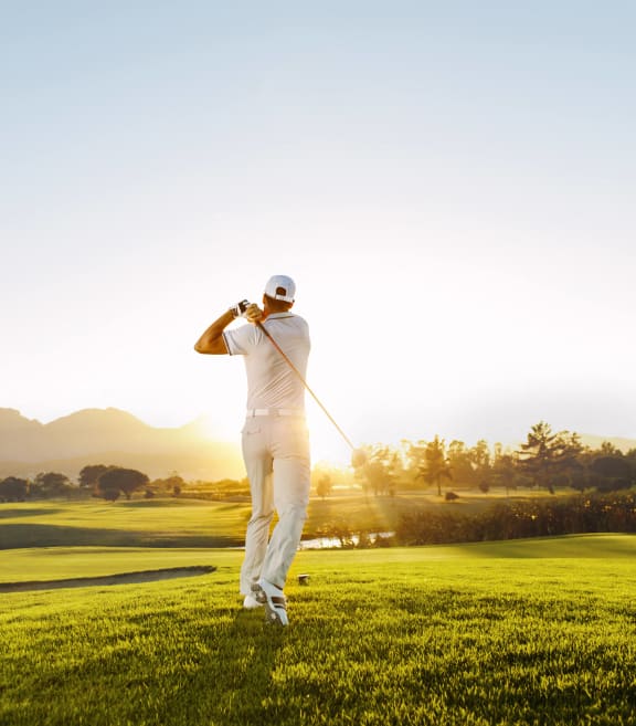 a man standing on a golf course holding a club