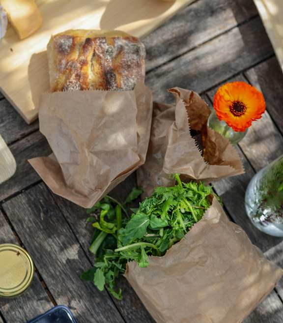 a picnic with cheese bread and wine on a blanket