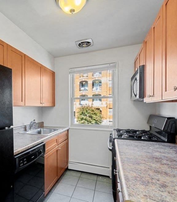 a kitchen with black appliances and wooden cabinets