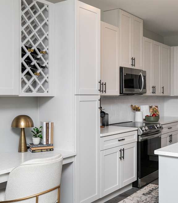 A modern kitchen with white cabinets and a white countertop. at The Cunningham Apartments, West Des Moines