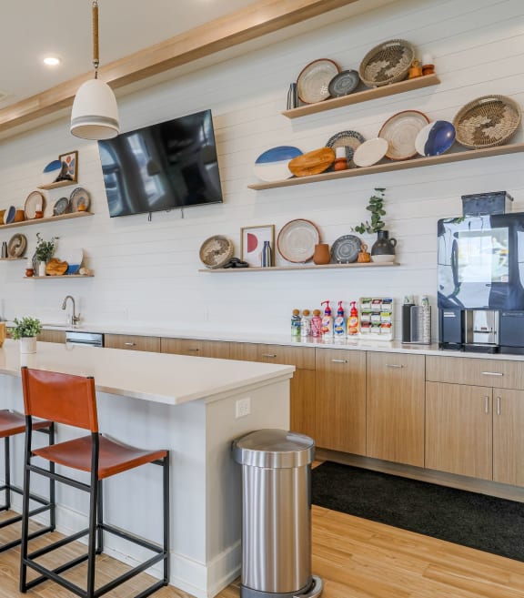 a kitchen with a counter and chairs and a coffee machine