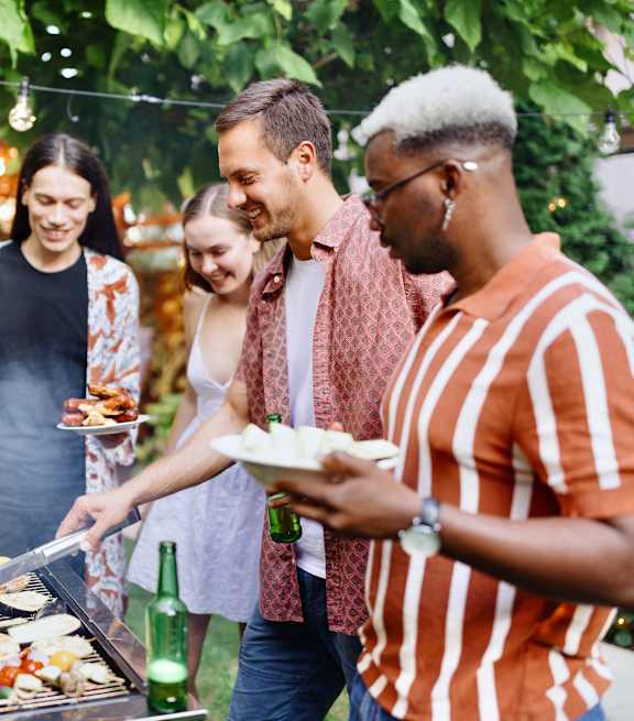 A group of people are gathered around a barbecue grill.