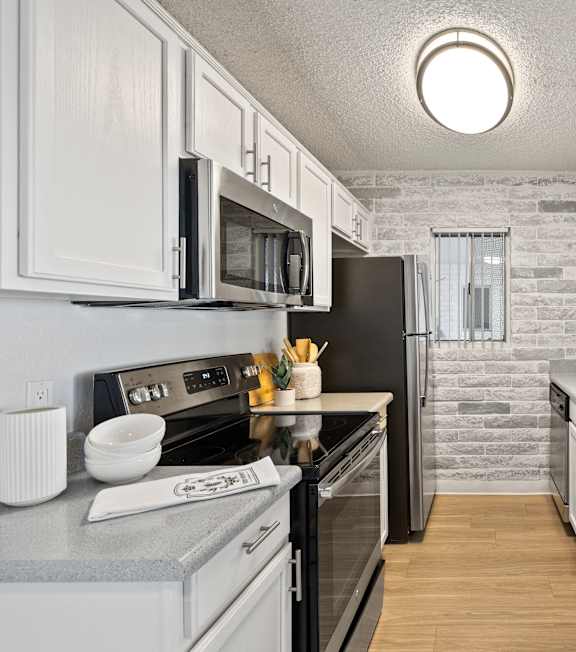 a kitchen with white cabinets and a black stove and a sink