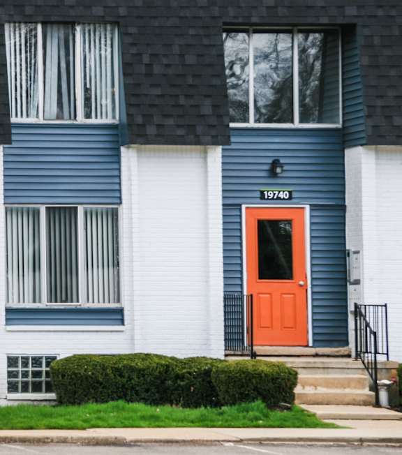 A blue and white house with a red door.