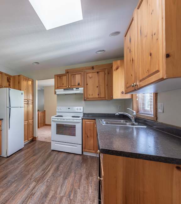 A kitchen with wooden cabinets and a black countertop.
