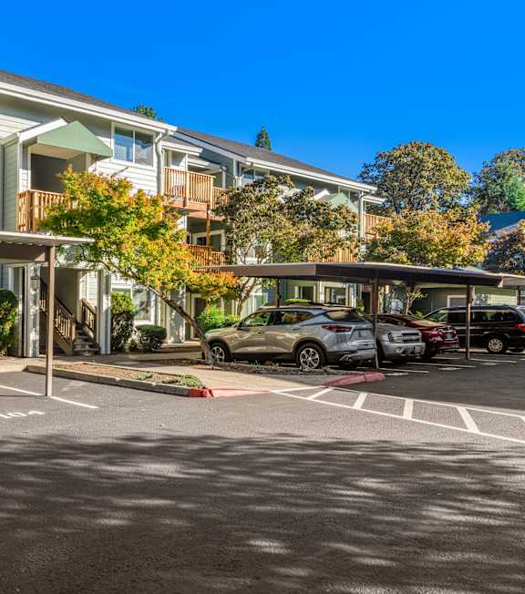 A parking lot with cars and apartment buildings in the background.