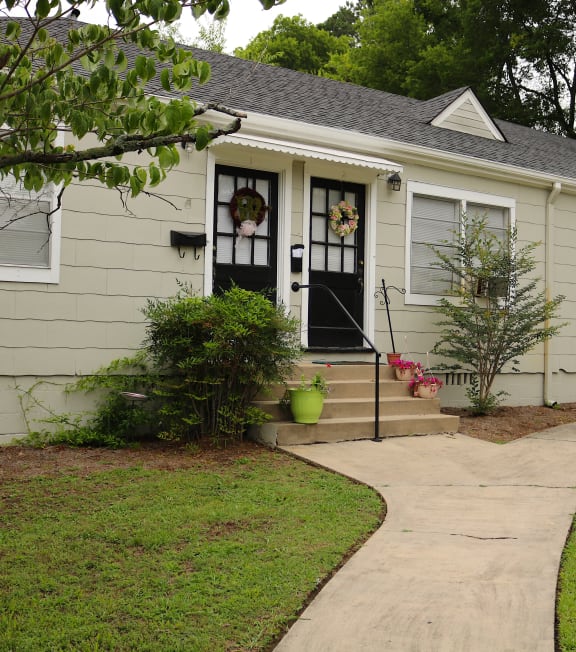 the front of a house with a sidewalk in front of it