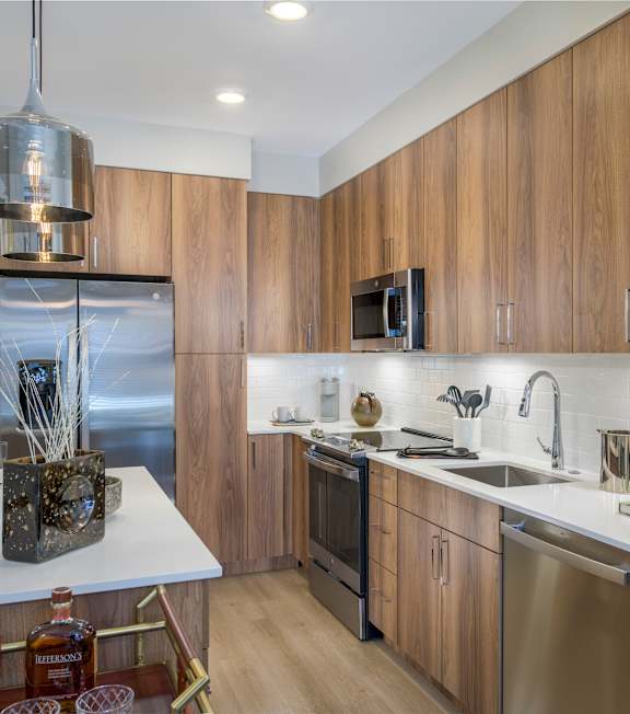 A modern kitchen with wooden cabinets and stainless steel appliances.