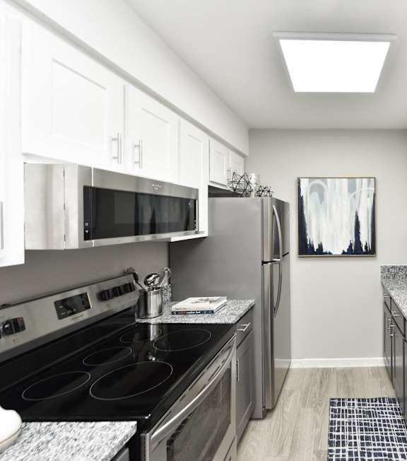 A kitchen with a black counter top and stove.