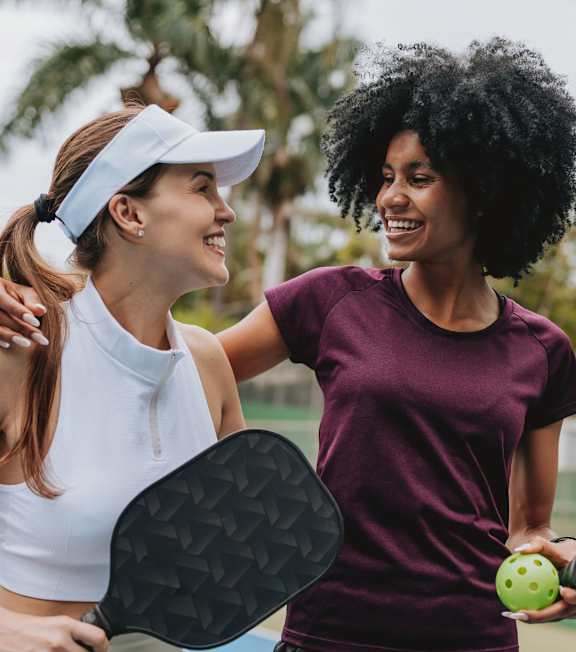 Two women playing tennis on a court.