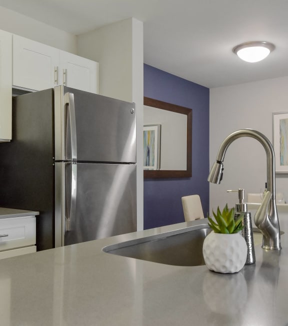 an open kitchen with stainless steel appliances and a counter top