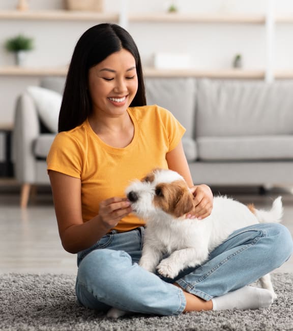a woman sitting on the floor petting a small dog at The Rail, St. Louis, 63110
