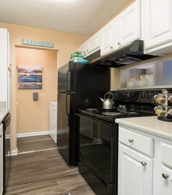 a kitchen with black appliances and white cabinets