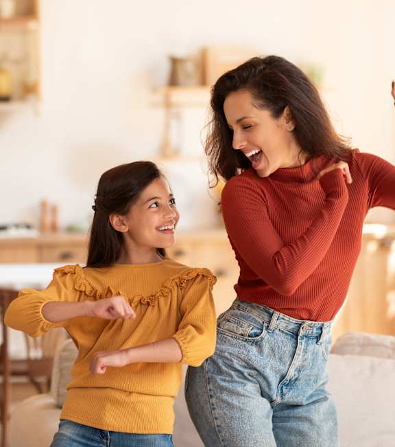 Two women dancing in a kitchen.