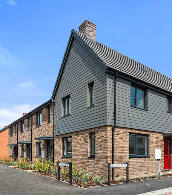 A modern house with a grey front and a green door at The Foundry Apartments, Bordon