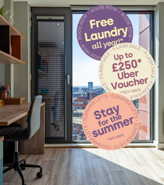 A room with a desk and a chair with a sign that says Free Laundry Pass All Year! on the window.
