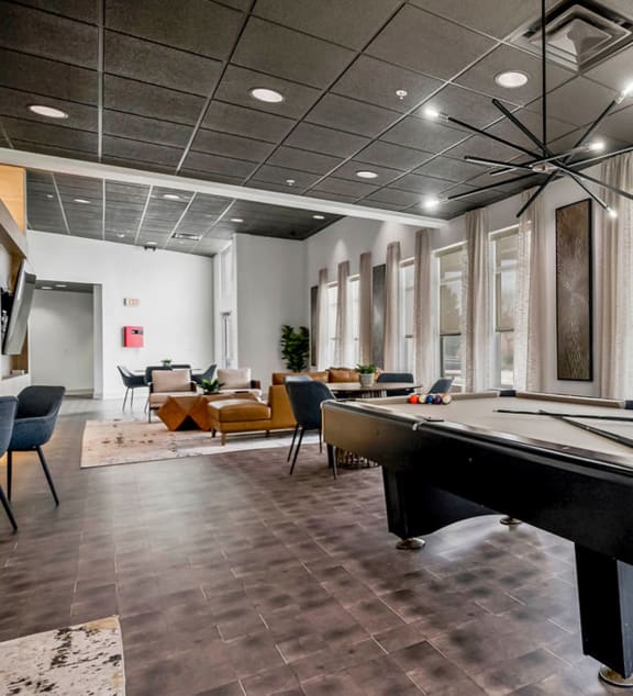 a game room with a pool table and windows at CityView, North Kansas City, Missouri