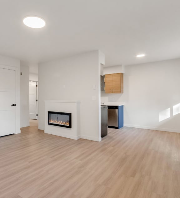a living room with a fireplace and a door into a kitchen