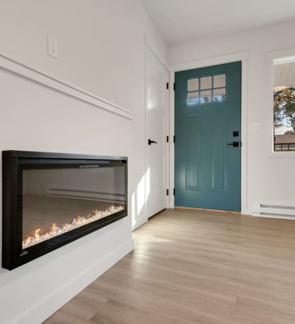 a living room with a fireplace and a blue door