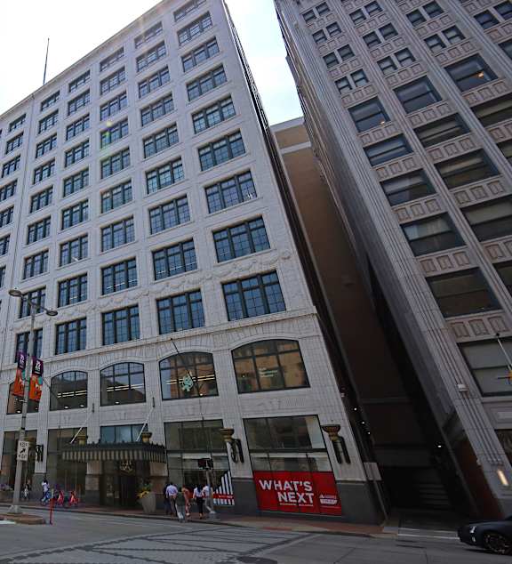 A tall white building with a red sign that says "What's Next" on the front.