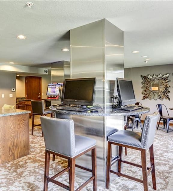 a kitchen with white cabinets and a wooden table at The Falls, Mission, KS