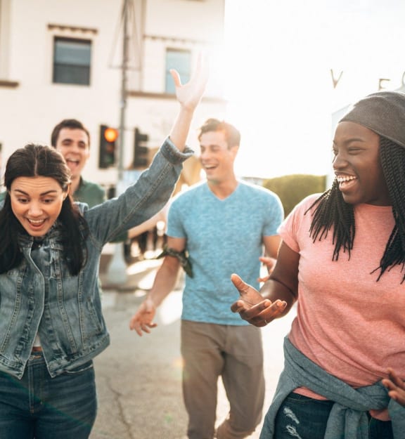 group of young people laughing and dancing in the street