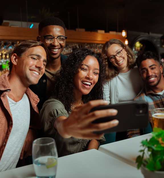 A group of friends taking a selfie in a bar.