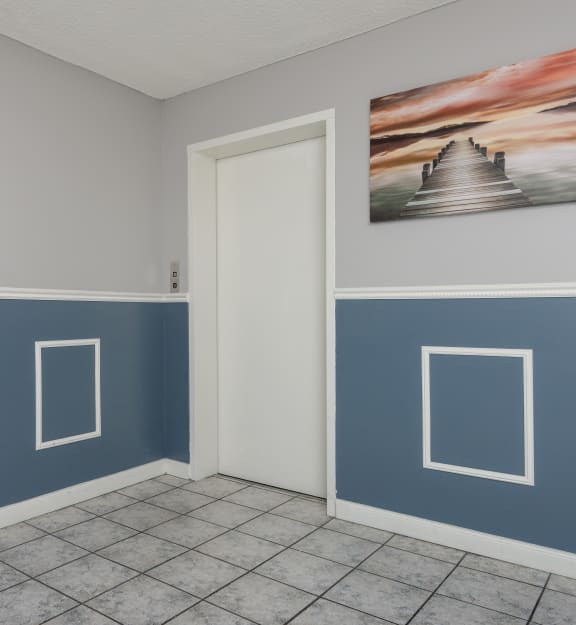 a room with blue walls and a painting on the wall
