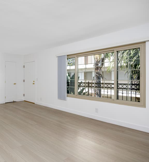 a living room with white walls and a large window